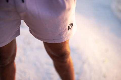 Duotone Sweat Shorts Onshore in dusty rose beim Posieren am Sandstrand