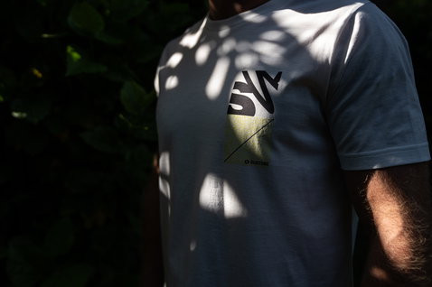 Duotone Apparel Tee 4the Team SS uomo maglia ciclismo in posa in giardino esterno con sfondo di fogliame