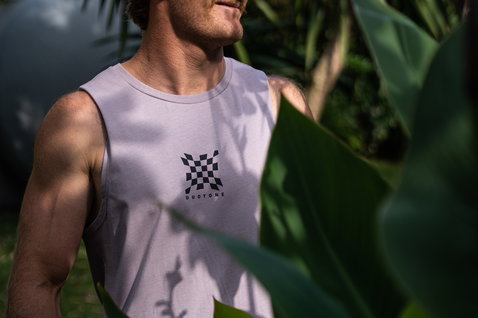Duotone Apparel Tank men tank top during a standing pose in a tropical garden