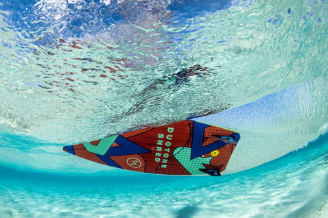 Duotone Shred twin-tip kiteboard during kitesurfing in a tropical ocean with shallow water