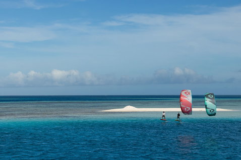 Duotone Neo LEI kite during wing foiling on tropical ocean reef with white sand bar