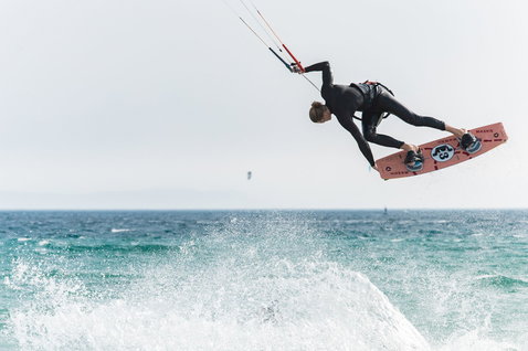 Duotone Evo SLS LEI Kite beim Kitesurfen am Meer in staubigem Pink und Lachs
