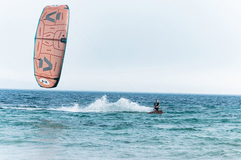 Duotone Evo SLS LEI Kite 12m in lachsrosa beim Kitesurfen auf dem Meer
