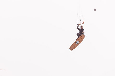 Duotone Entity Ergo Black Edition 2024 twin-tip kiteboard during kitesurfing under overcast sky