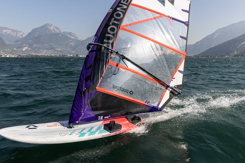 Duotone Falcon Fin D/LAB planche de windsurf lors du windsurf sur un lac alpin avec montagnes