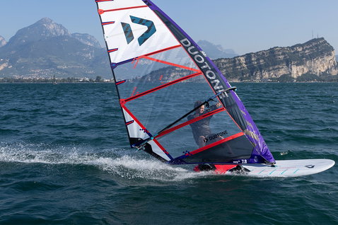 Duotone Falcon_Fin D/LAB 2024 planche de windsurf pendant le windsurf sur lac alpin avec montagnes