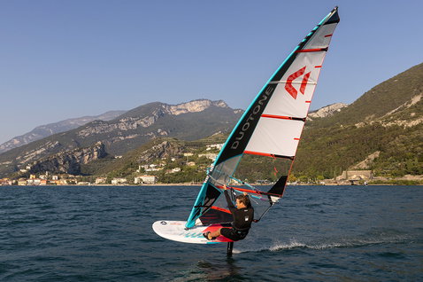 Duotone Warp_Foil foil sail during foiling on a lake with mountain backdrop
