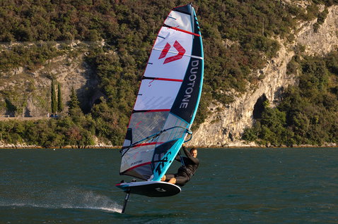 Duotone Warp_Foil foil sail during foiling on a mountain lake, likely Lake Garda, Italy