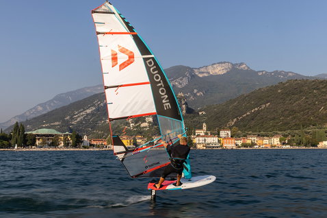 Duotone Warp Foil foil sail during foiling on alpine lake with village and mountains in background
