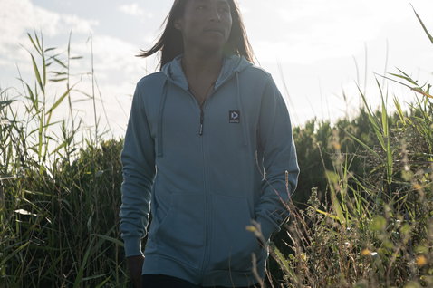 Zip-up hoodie in light grey-blue outdoors on a meadow