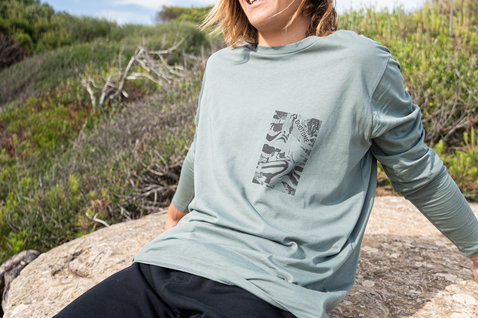 Duotone Kiteboarding Tee Team LS unisex camiseta de manga larga en verde salvia sobre afloramiento rocoso costero