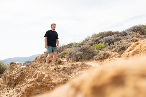 Duotone Boardshorts DT 17inch Herren beim Windsurfen an Küstendünen mit Buschvegetation