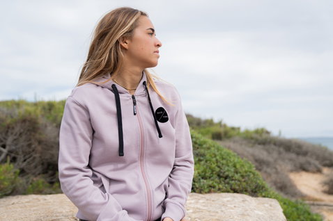 Duotone Apparel Hoody Team Zip sweat zippé femme en gris lavande avec détails noirs sur des falaises côtières