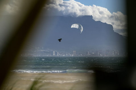 Duotone Evo Concept Blue LEI Kite beim Kitesurfen am Strand mit Stadtsilhouette und Tafelberg