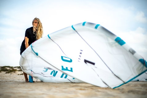 Duotone Neo Concept Blue LEI kite during wave riding at an ocean beach with sand dunes
