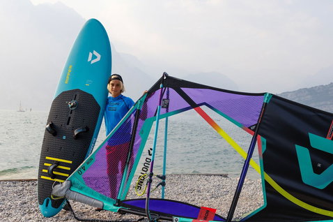 Board de windsurf Duotone Ripper en train de faire du windsurf sur un lac avec montagnes