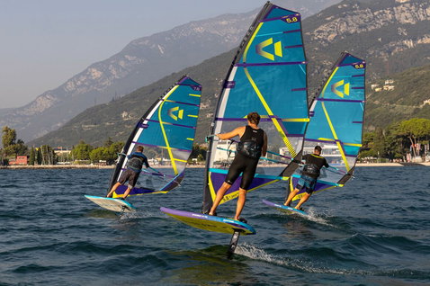 Duotone Stingray SLS windsurf board during wing foiling on an alpine lake with mountain backdrop