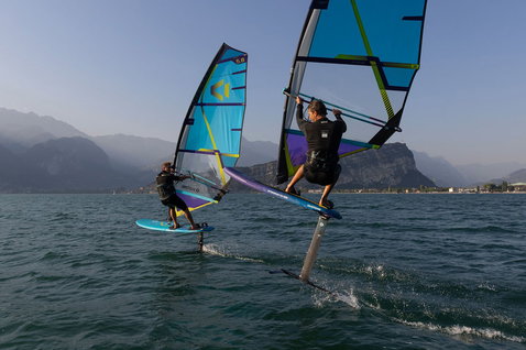 Duotone Stingray SLS 2025 windsurf board during foiling on an alpine lake with mountain backdrop