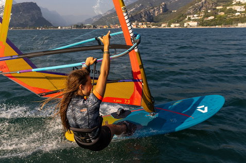 Duotone Eagle SLS windsurf board while windsurfing on a mountain lake