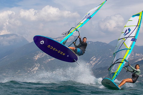 Duotone Eagle SLS windsurf board during windsurfing on a lake with mountain backdrop