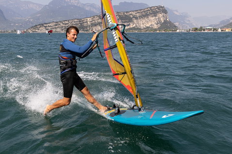 Duotone Eagle SLS windsurf board during freeride on an alpine lake with mountain backdrop