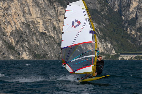 Duotone Blast SLS Windsurf-Board beim Freeride Windsurfen an einem Alpensee mit Felsklippen