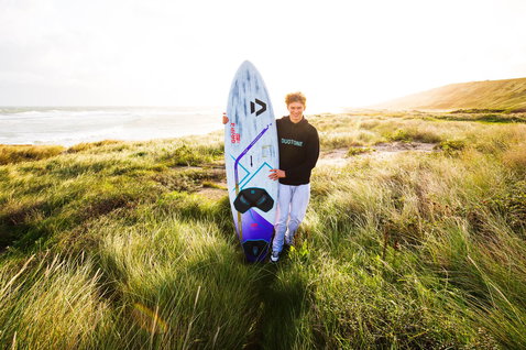 Duotone Grip 4 >< Grip 3 D/LAB windsurf board during wave riding at coastal dunes with ocean