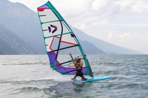 Voile de windsurf freeride Duotone E_Pace HD 5,8 m² en action sur un lac alpin en turquoise, violet et blanc