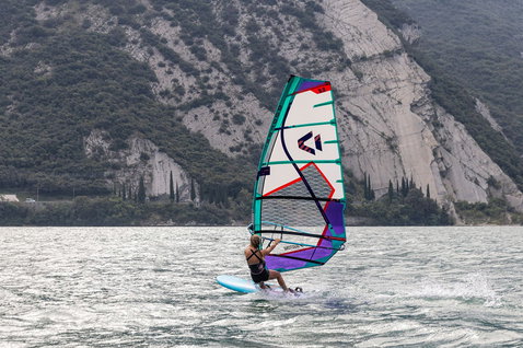 Voile de windsurf freeride Duotone E_Pace HD lors d'une session de windsurf sur un lac alpin en blanc, turquoise et violet
