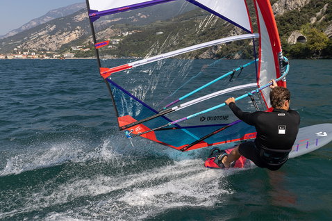 Duotone Jag SLS planche de windsurf lors du windsurf sur un lac alpin avec falaises de montagne en arrière-plan