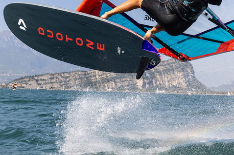 Planche de windsurf Duotone Jag SLS lors de windsurf sur un lac de montagne avec falaises rocheuses en arrière-plan