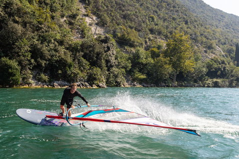 Duotone Jag SLS planche de windsurf lors d'une session de windsurf sur un lac intérieur avec des montagnes boisées
