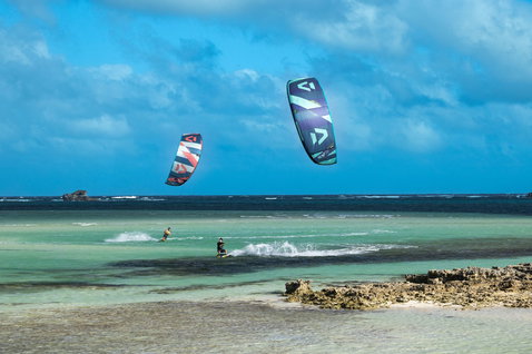 Duotone Evo SLS LEI Kite beim Kitesurfen in einer tropischen Lagune mit Sandstrand