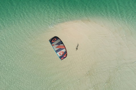 Duotone Evo SLS LEI Kite beim Kitesurfen auf einer tropischen Sandbank mit türkisblauem Flachwasser