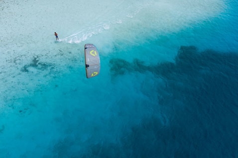 Duotone Neo D/LAB LEI kite during wave riding on a tropical ocean reef flat with shallow turquoise water