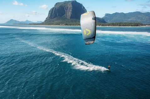 Duotone Neo D/LAB LEI kite during wave riding in a tropical ocean lagoon with mountain backdrop