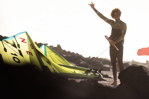Duotone Neo SLS LEI kite while wave riding at a rocky coastal shoreline