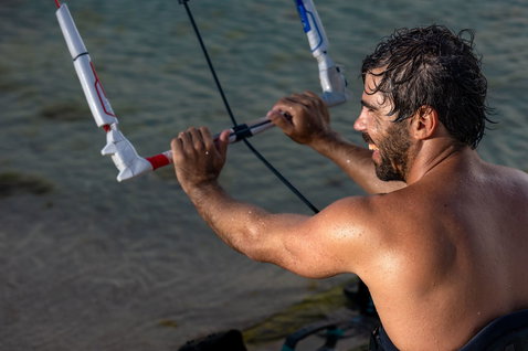Duotone Click Bar Quad Control 2025 control bar during kitesurfing on an ocean beach