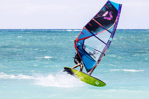 Planche de windsurf Duotone Ultra FreeWave SLS pendant le surf de vagues sur la plage de l'océan