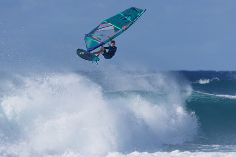 Duotone Grip 3 SLS windsurf board during wave riding at ocean beach with breaking waves
