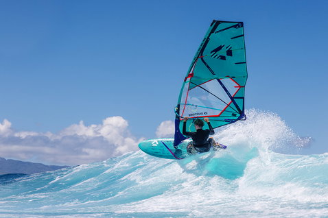 Duotone Grip 3 SLS windsurf board during windsurfing on ocean waves at a tropical coastline