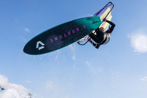 Duotone Grip 3 SLS windsurf board during wave riding on the ocean at a tropical beach