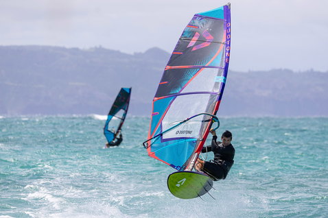 Duotone Duke wave sail during wave riding in open ocean with hills in background