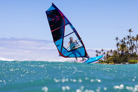 Duotone Duke 2025 wave sail during wave riding at a tropical ocean coastline with palm trees