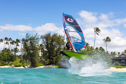 Duotone Duke 2025 wave sail during wave riding at a tropical beach lagoon with palm trees