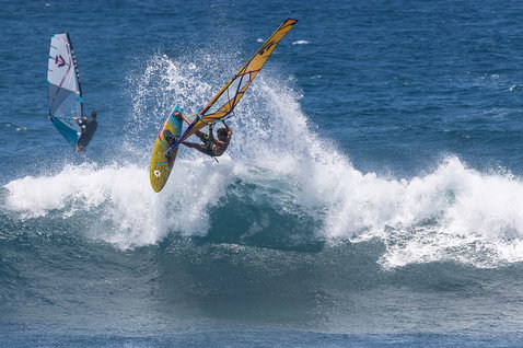 Duotone Grip 4 SLS windsurf board during wave riding at the ocean beach in steel blue and yellow