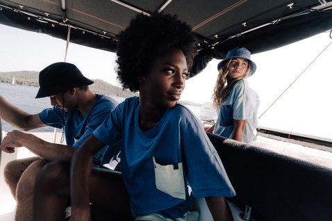 Bucket hat during beach lifestyle on a sailing boat with ocean and coastal hills in the background