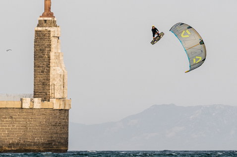 Duotone Trust Bar Quad Control D/LAB Steuerbar beim Kitesurfen an einer Küste mit Leuchtturm