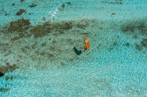 Cerf-volant LEI Duotone Rebel SLS lors du kitesurf au-dessus d'un lagon tropical avec récif corallien en teal