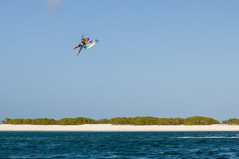Duotone Rebel SLS LEI kite during kitesurfing at a tropical coastal lagoon with mangroves and white sand beach